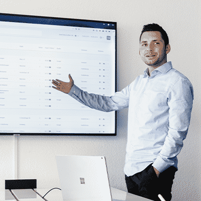 An employee is pointing on a large screen, showing the SalesViewer® interface