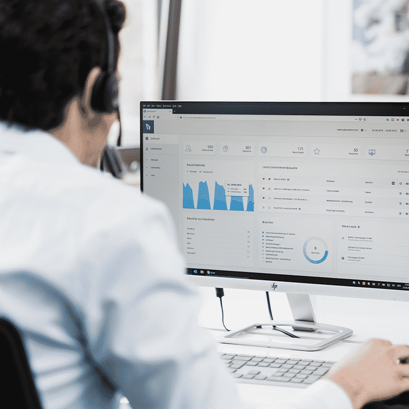Male employee in front of a desktop PC showing the SalesViewer® Interface