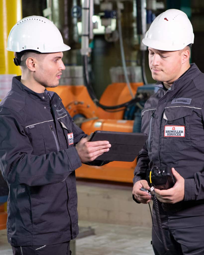Zwei Baumüller Services Techniker in einer Betriebshalle