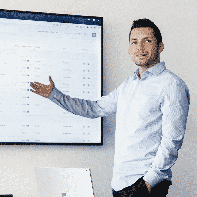 Ein SalesViewer® Mitarbeiter deutet auf einen Bildschirm
